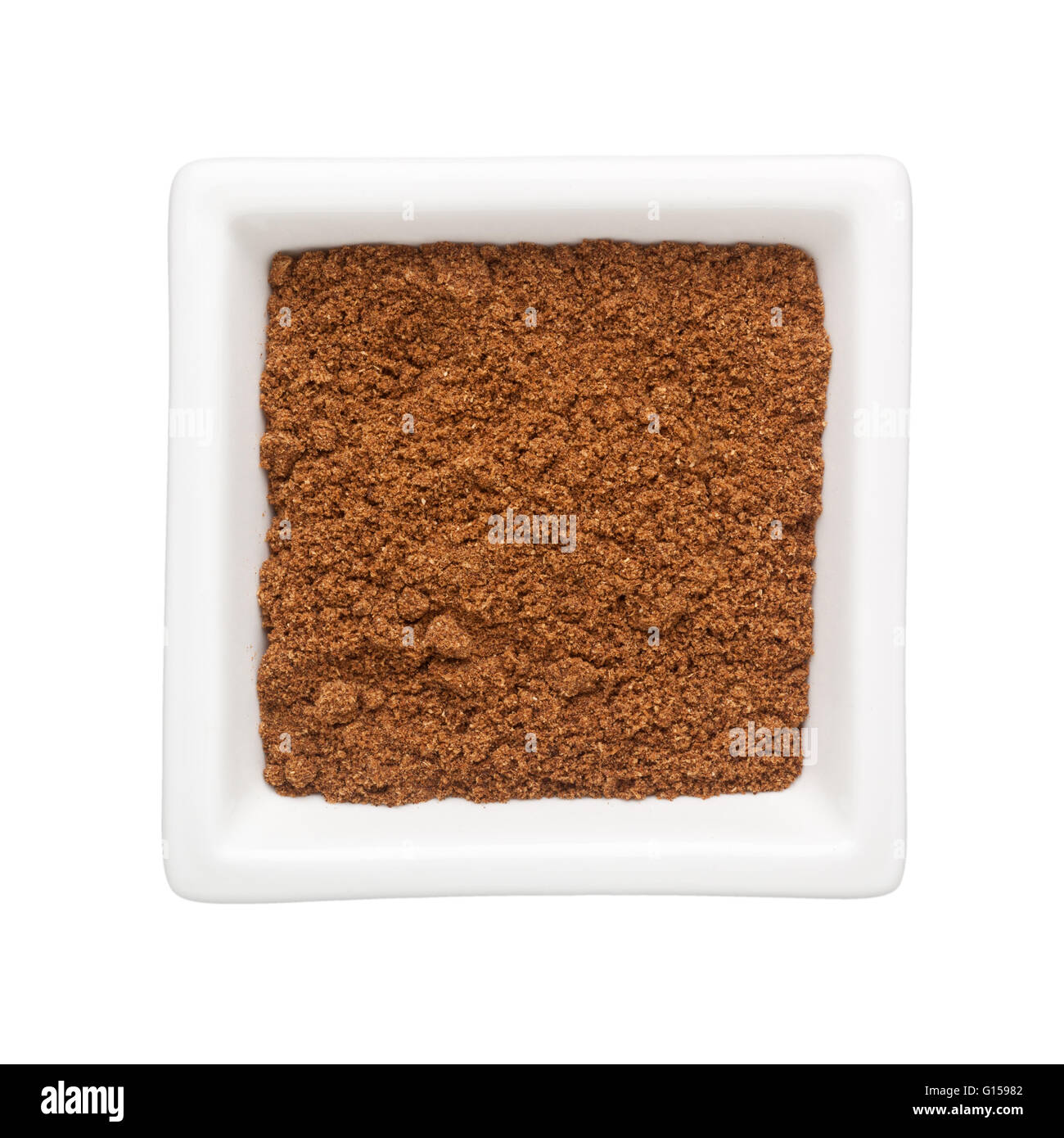 Il coriandolo in polvere in un recipiente quadrato isolato su sfondo bianco Foto Stock