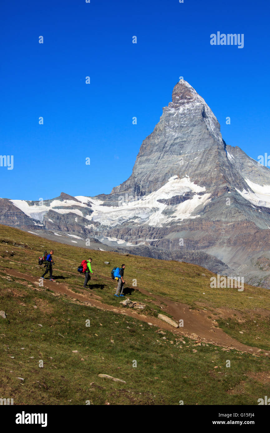 Gli escursionisti procedere con il Cervino sullo sfondo in una chiara giornata estiva, Gornergrat, Canton Vallese, alpi svizzere, Svizzera Foto Stock
