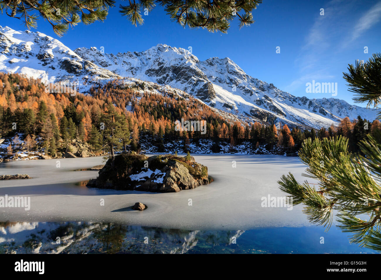 Autunno riflessi al Lago Saoseo ancora parzialmente congelato, Valle di Poschiavo, Cantone dei Grigioni, Svizzera, Europa Foto Stock