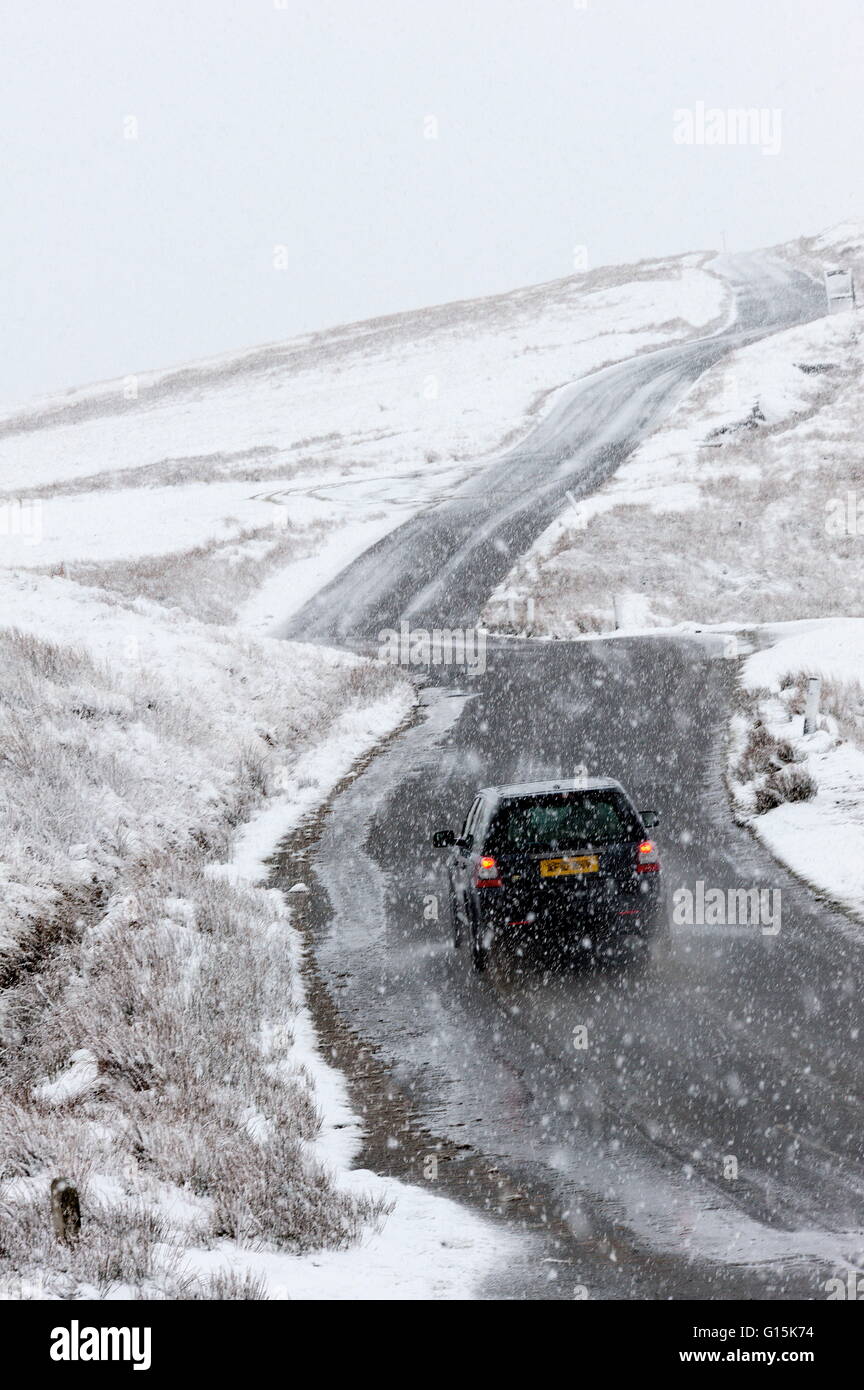 Una vettura negozia una strada attraverso un paesaggio invernale nell'Elan zona di valle in Powys, Wales, Regno Unito, Europa Foto Stock