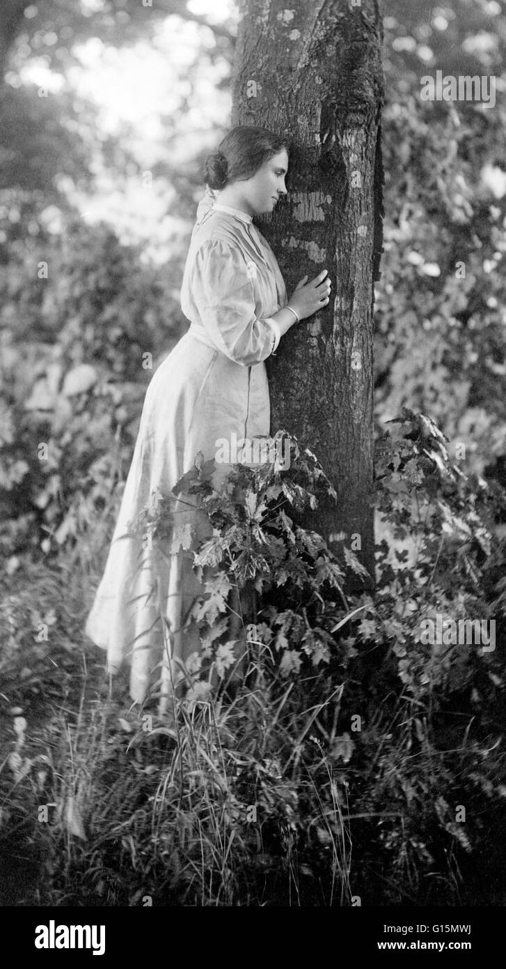 Keller in piedi accanto ad albero, circa 1907. Helen Adams Keller (Giugno 27, 1880 - Giugno 1, 1968) era un autore americano, attivista politico, e docente. Aveva 19 mesi quando ha contratto una malattia che potrebbe essere stata scarlattina o meningite, Foto Stock