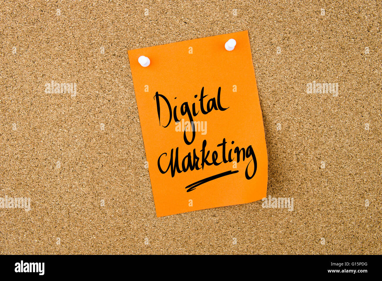 Il marketing digitale scritto su carta arancione nota appuntata sulla bacheca di sughero con il bianco thumbtacks, copia dello spazio disponibile Foto Stock