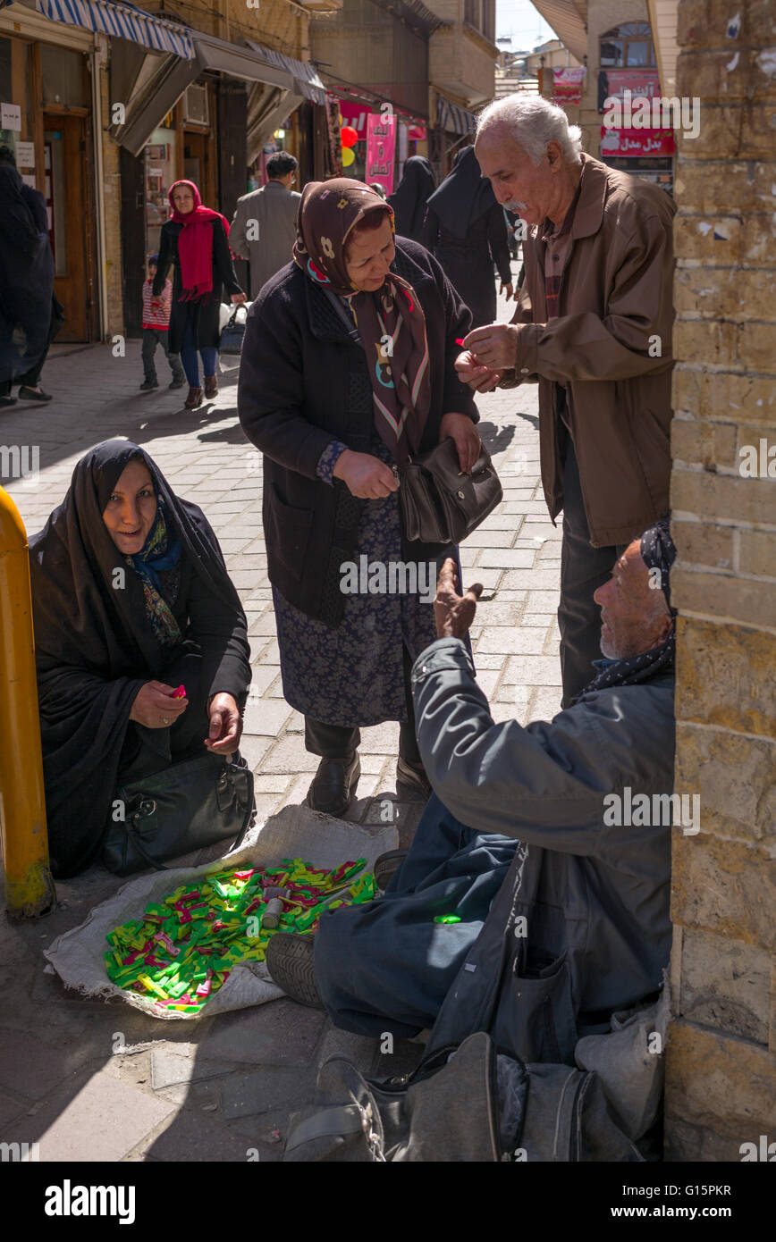 Uomo seduto sul marciapiede dimostrando ago automatico-filiera in Hamadan, Iran. Foto Stock