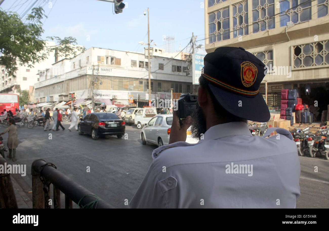 Il personale di polizia fare film di pendolari passando attraverso la strada vicino a Zainab Mercato in Karachi lunedì 09 maggio, 2016. Le autorità di polizia consegnato le fotocamere digitali per il personale per la realizzazione di film di pendolari presunta nel segnale di traffico violazione. Foto Stock