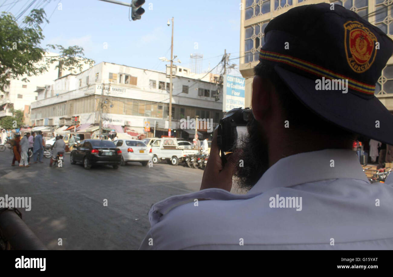 Il personale di polizia fare film di pendolari passando attraverso la strada vicino a Zainab Mercato in Karachi lunedì 09 maggio, 2016. Le autorità di polizia consegnato le fotocamere digitali per il personale per la realizzazione di film di pendolari presunta nel segnale di traffico violazione. Foto Stock