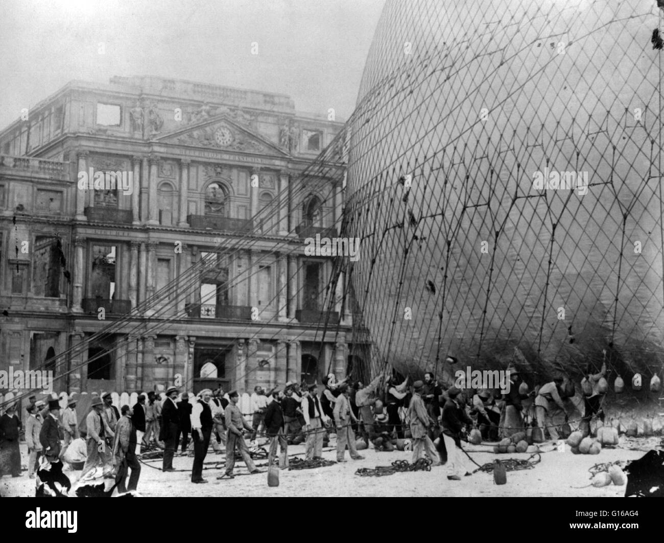 Giffard della balloon in preparazione per la salita da giardini Tuilerie, Parigi. Nota Il bruciate le rovine del palazzo delle Tuileries in background. Henri Giffard (8 febbraio 1825 - 14 Aprile 1882) era un ingegnere francese. Ha inventato l'iniettore e la Giffar Foto Stock