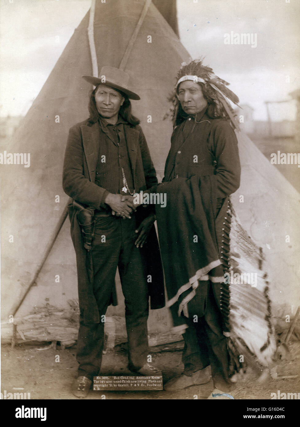 Due capi Oglala, American Cavallo (indossare abbigliamento occidentale e la pistola in fondina) e Red Cloud (INDOSSARE COPRICAPO), agitando le mani davanti tende Tepee, probabilmente su o in prossimità di Pine Ridge Prenotazione. Fotografato da John C.H. Grabill, 1891. Cavallo americano (1840 - Foto Stock