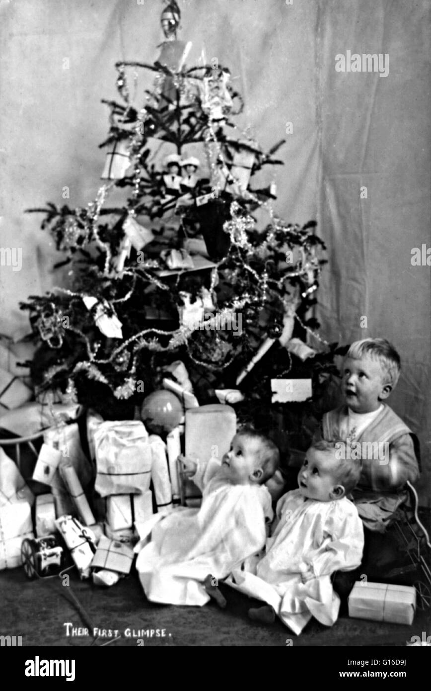 Titolo: " il loro primo assaggio' che mostra tre piccoli bambini con albero di Natale e regali. Uno dei motivi principali per cui abbiamo l'abitudine di dare e di ricevere regali a Natale, per ricordarci la presenta dato a Gesù dai Saggi: Frankie Foto Stock