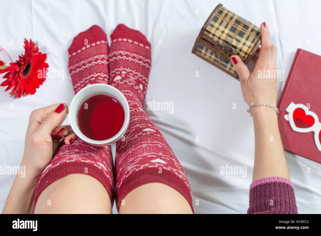Donna con una tazza di tè nel letto, punto di vista Foto Stock