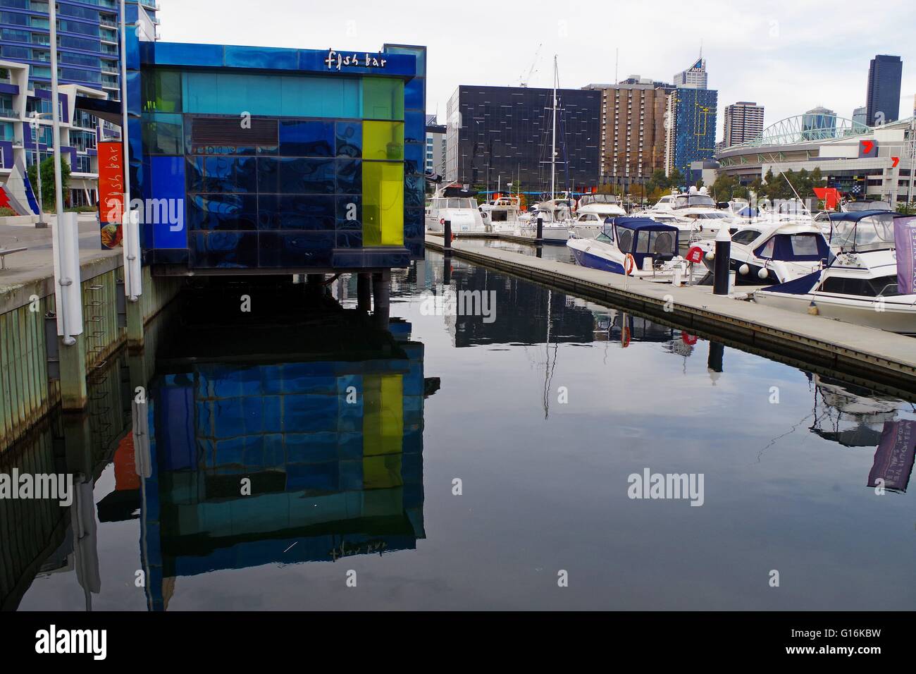 Arty Fish 'n Chip Shop immagine speculare sull'acqua in un porto con barche e di edifici alti Foto Stock