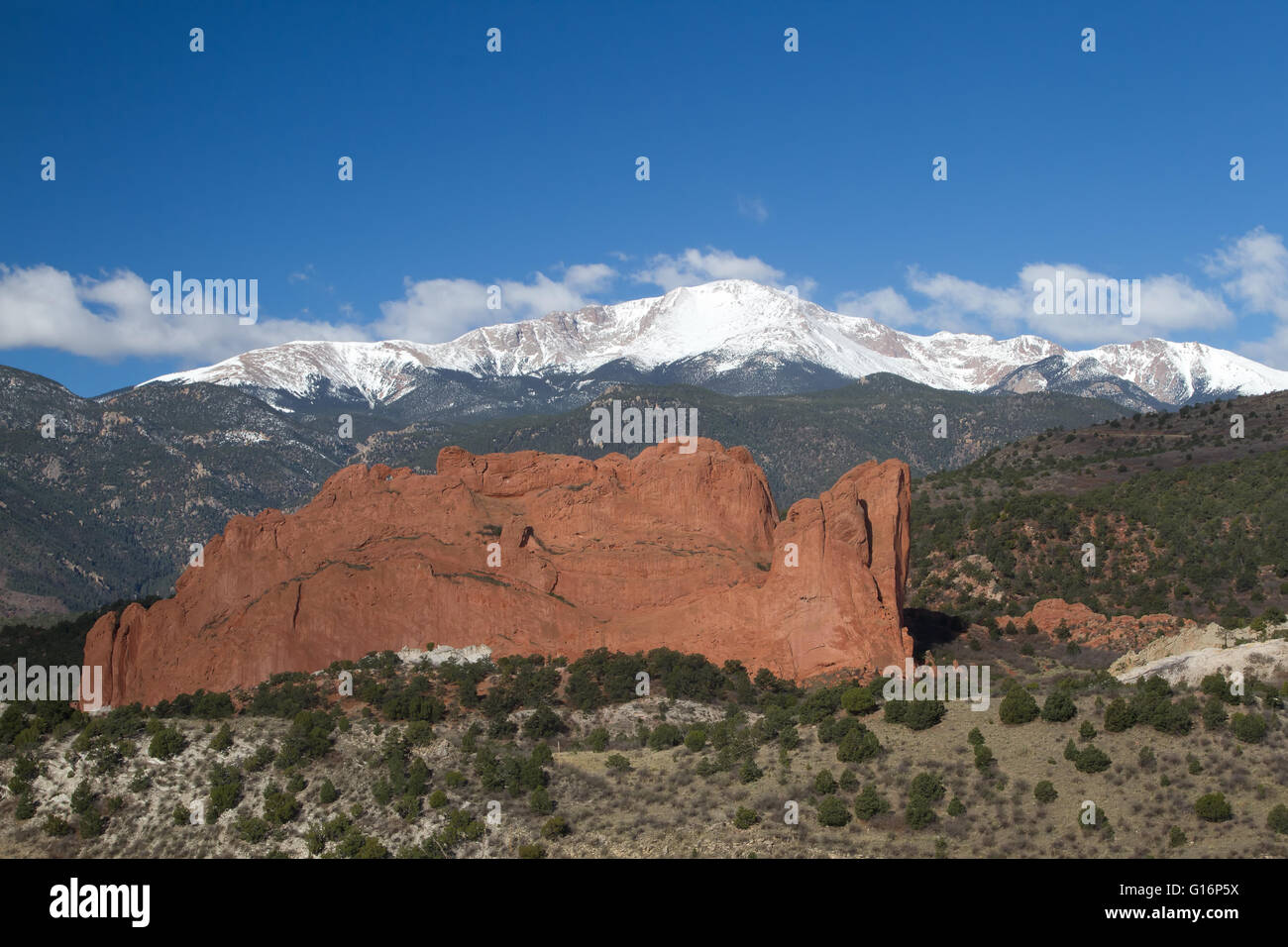 Nuvole roll over Pikes Peak in Colorado Springs con il red rock formazione del Giardino degli Dei Foto Stock