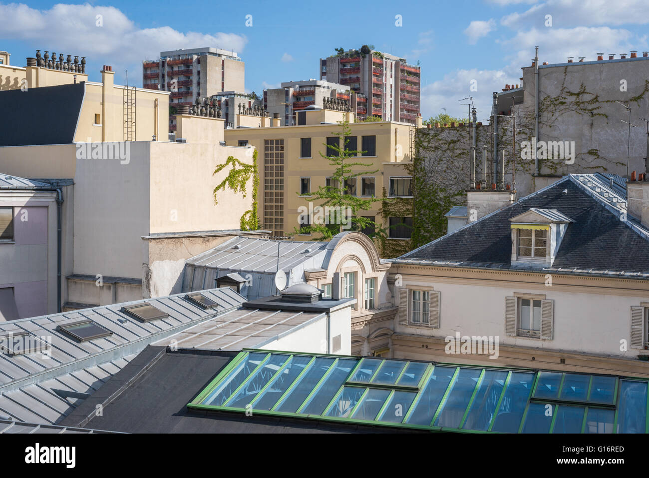 Cluster di tetti con lucernari in vetro e alimenti i giardini cercando attraverso il paesaggio urbano di Parigi, Francia Foto Stock
