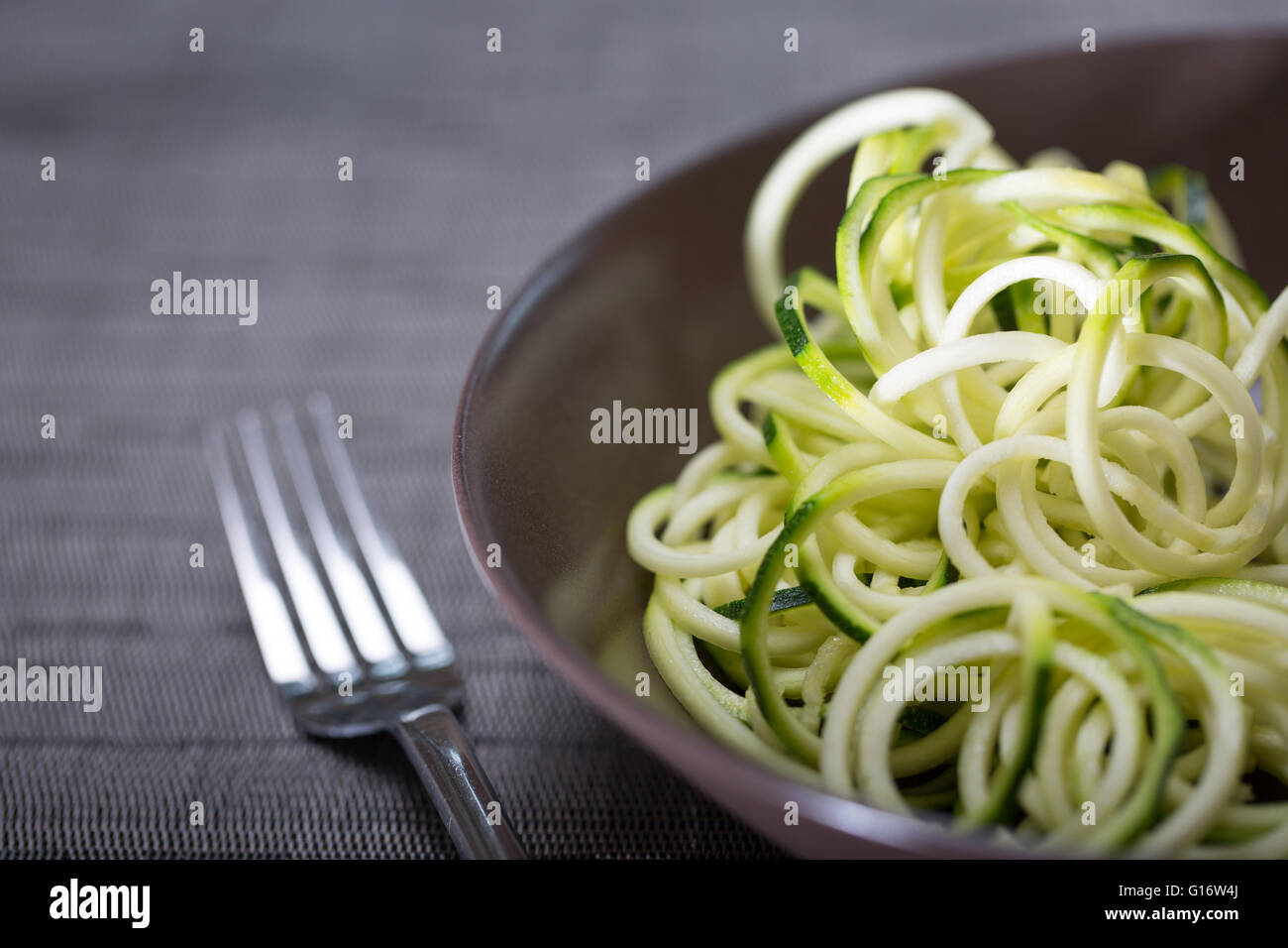 Una ciotola di zucchine (zucchine) tagliatelle (spaghetti) realizzato utilizzando un spiralizer Foto Stock