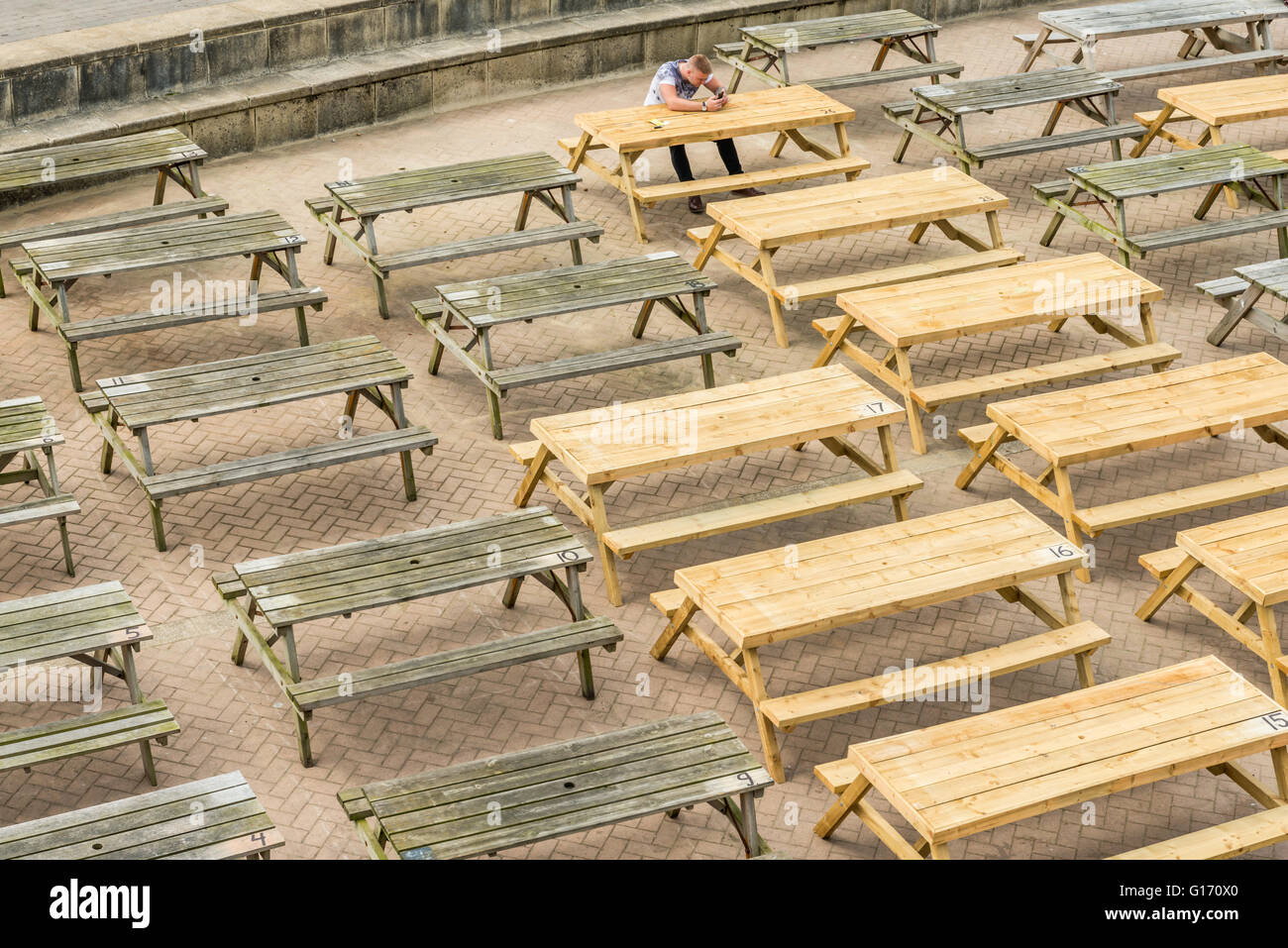 Brighton, Regno Unito - 7 Maggio 2016: Seaside tabelle sono pronte per lo start della stagione estiva. Un giovane uomo da solo Foto Stock