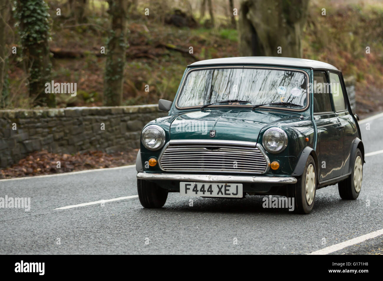 Un verde vintage Austin mini guida su strada Foto Stock