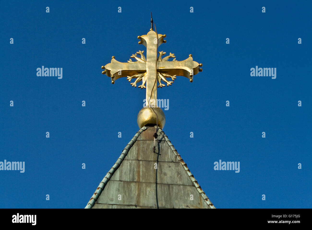 Golden Cross sulla chiesa oltre il cielo blu Foto Stock