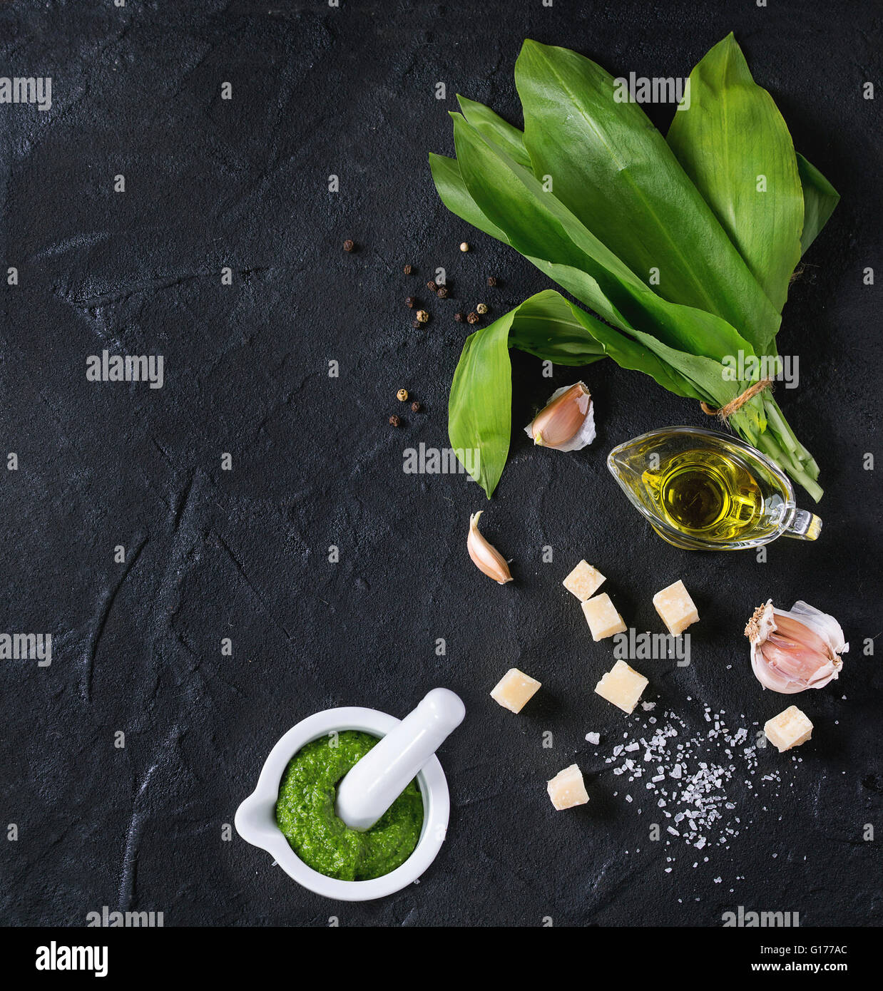 Ingredienti per il pesto e pesto di ramson in mortaio di ceramica. Mazzetto di ramson, olio d'oliva, Parmigiano grattugiato, aglio, sale e pepe o Foto Stock