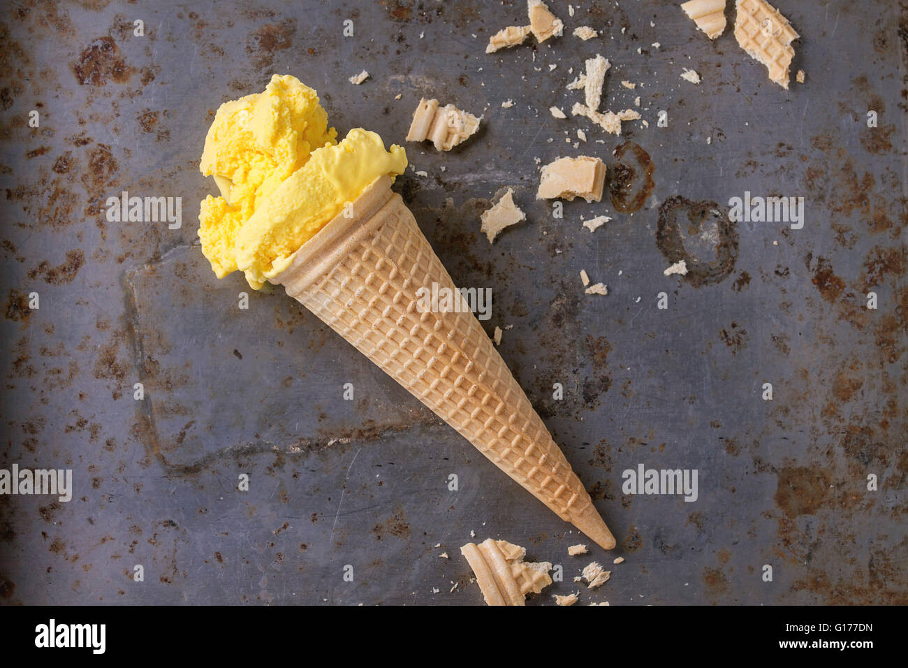 In casa mango gelato in cono di cialda di wafer con mollica su metallo arrugginito textured background. Vista superiore Foto Stock