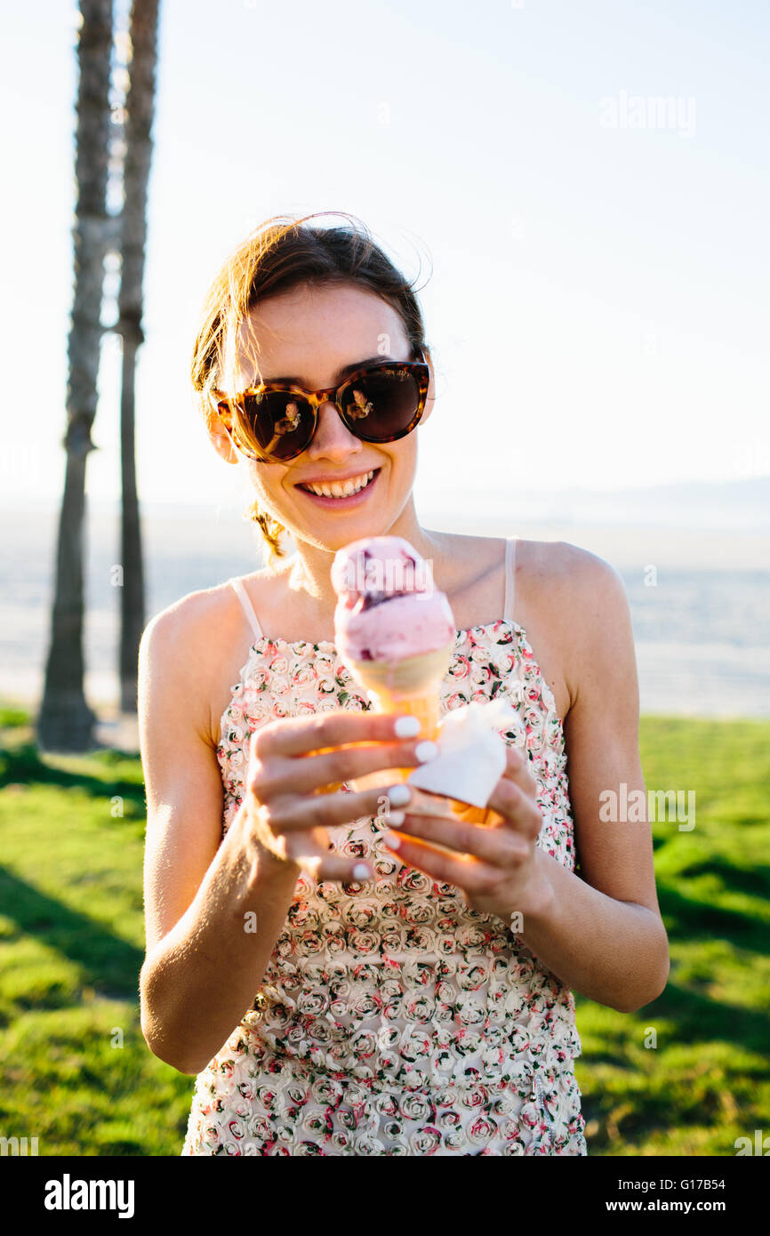 Ritratto di giovane donna a mangiare il gelato in cono costa, Venice Beach, California, Stati Uniti d'America Foto Stock