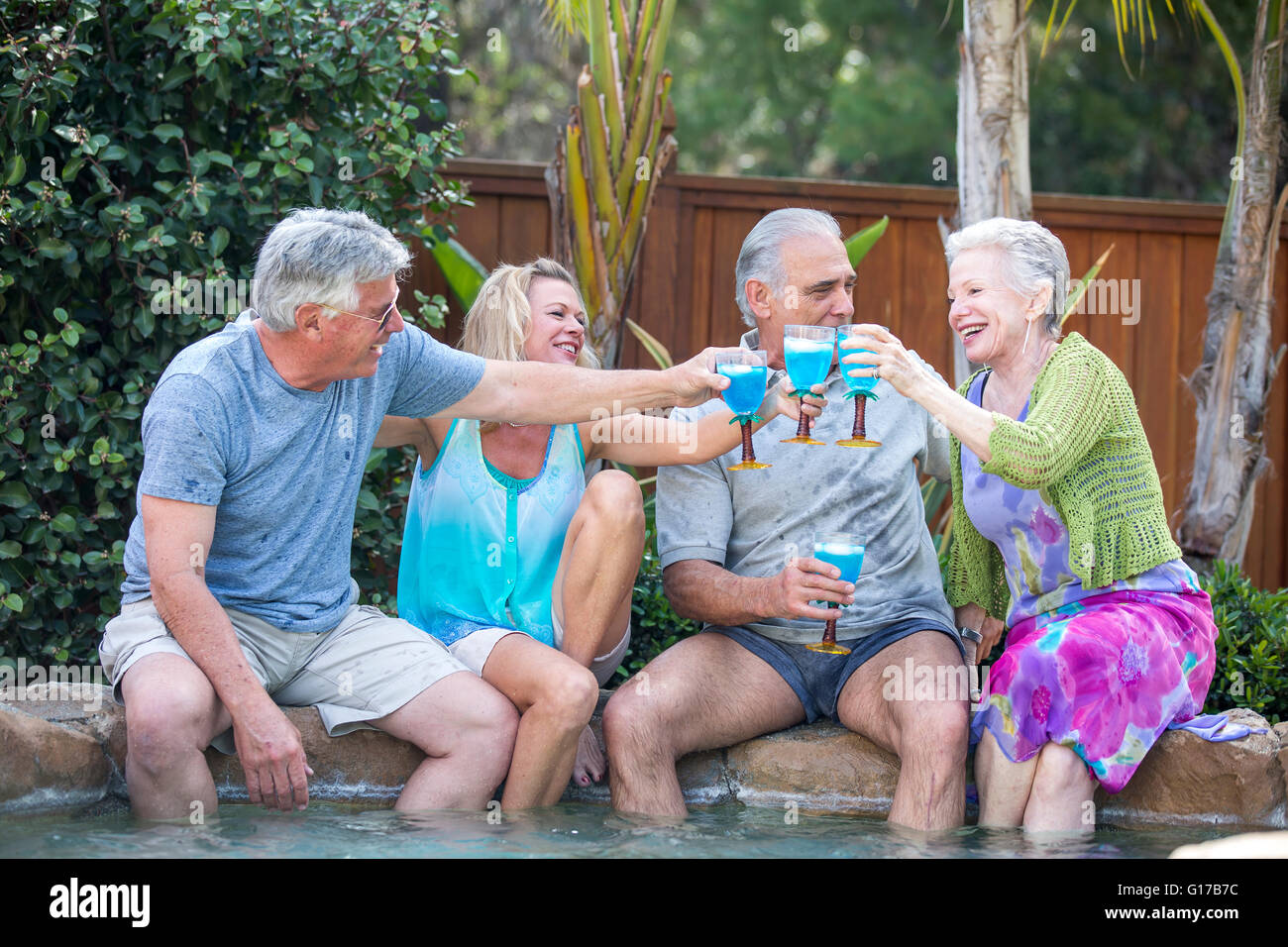 Gruppo di anziani la tostatura in piscina Foto Stock