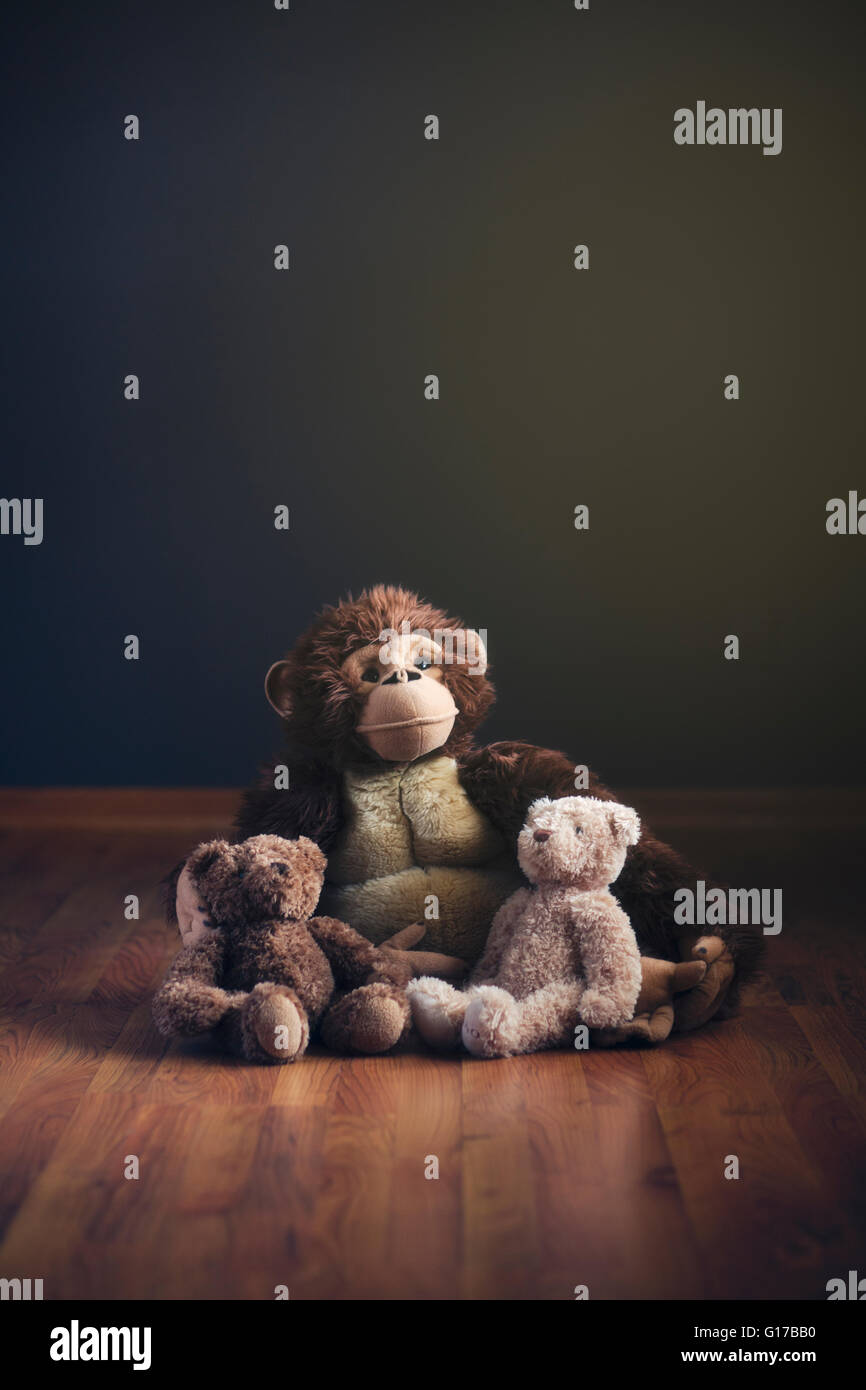 Giocattoli imbottiti seduta sul pavimento in legno Foto Stock