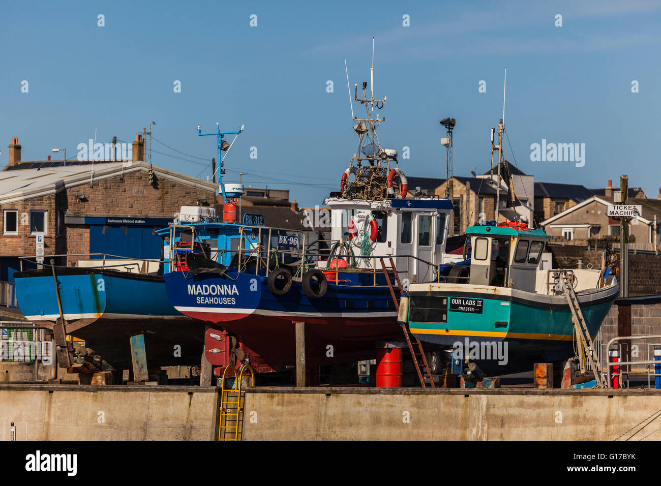 Barche da pesca al di fuori dell'acqua a Seahouses Harbour sottoposti a manutenzione stagionale Foto Stock