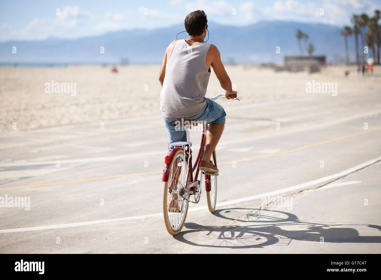 Vista posteriore dell'uomo in bicicletta a Venice Beach, Los Angeles, California, Stati Uniti d'America Foto Stock