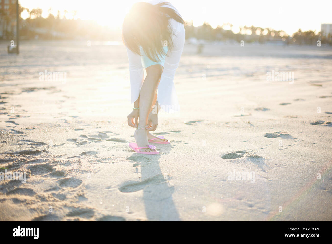 Donna piegatura per fissare anklet sulla spiaggia di Santa Monica Beach, Cresent City, California, Stati Uniti d'America Foto Stock