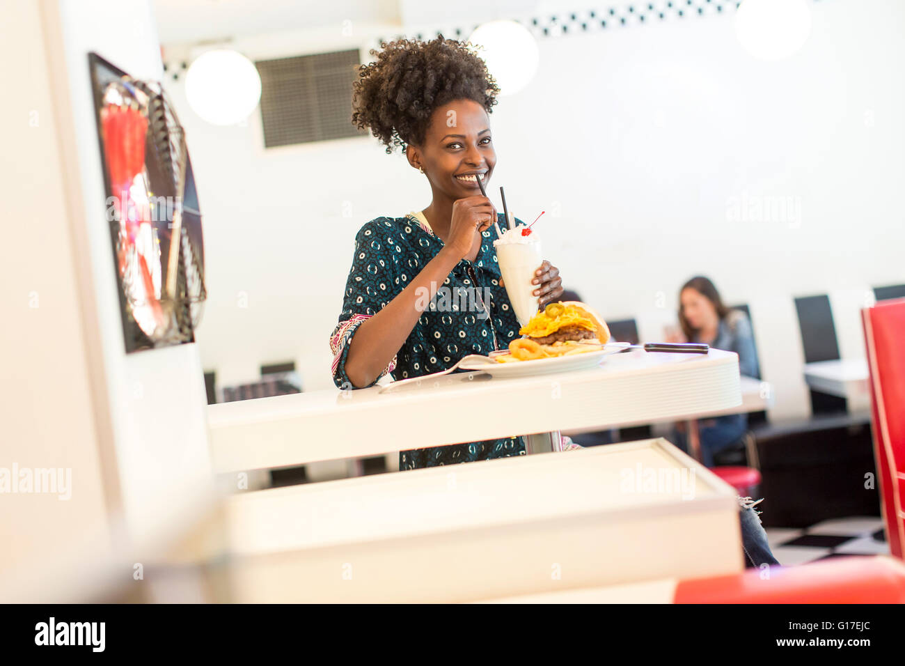 Giovane africano donna americana nel diner Foto Stock