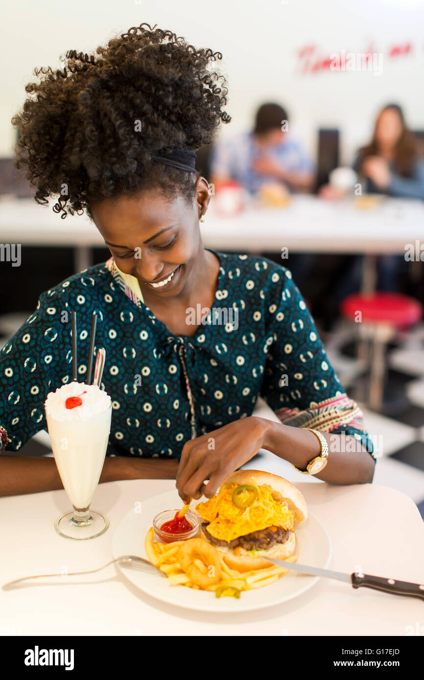 Giovane africano donna americana nel diner Foto Stock