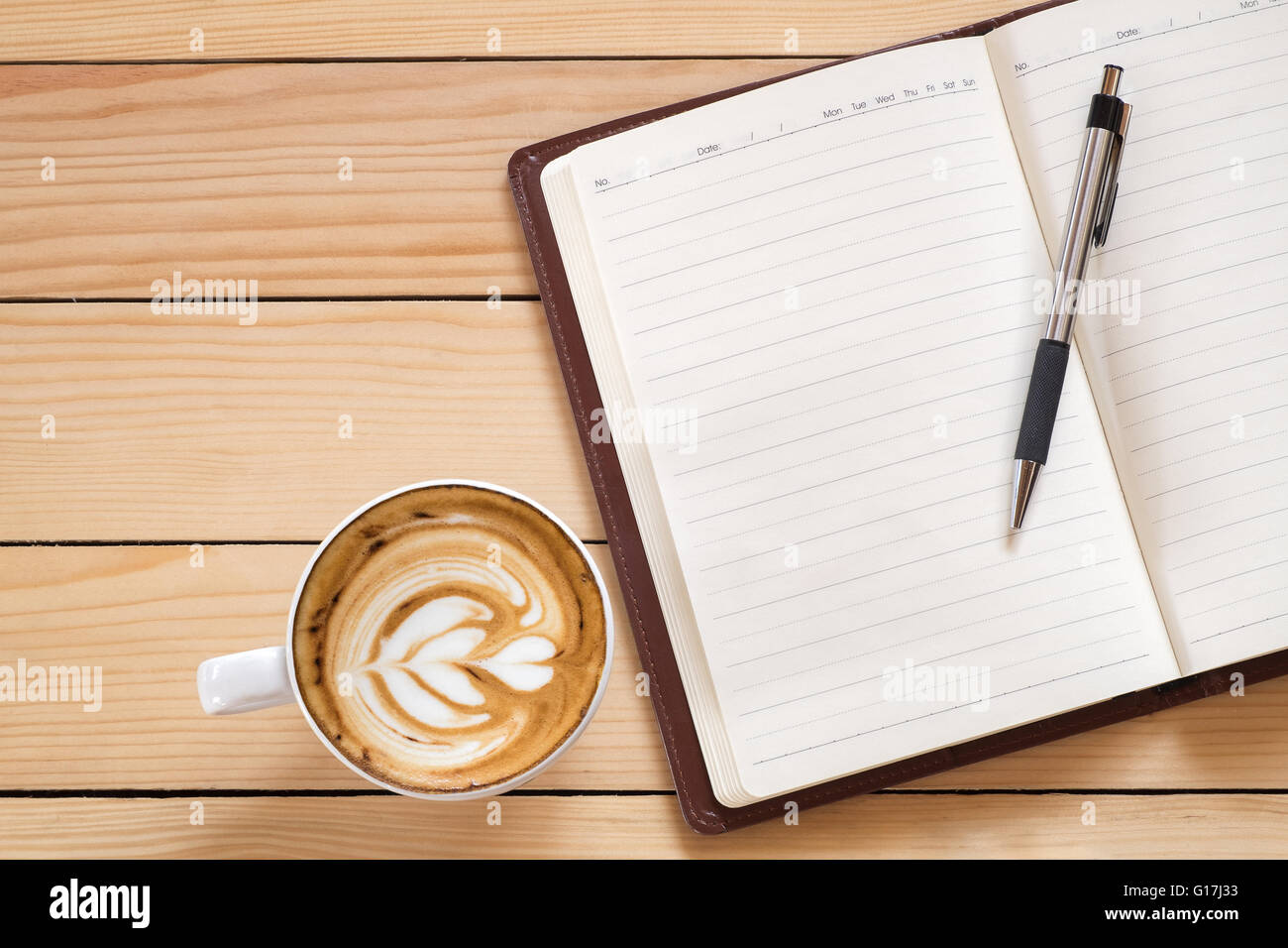 Notebook vuota con la penna e la tazza di caffè sul tavolo di legno, scrivania da ufficio concetto Foto Stock