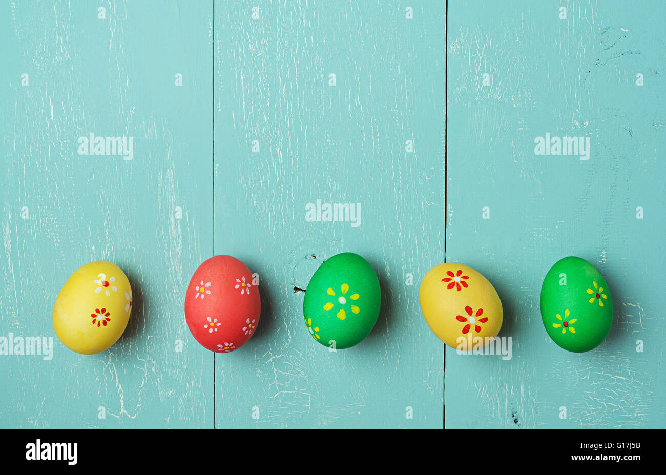 Multicolori uova di pasqua su vintage in legno dipinto con sfondo craquelure Foto Stock