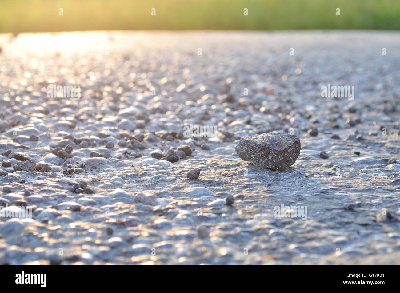Una roccia su asfalto con luce da angolo superiore sinistro Foto Stock