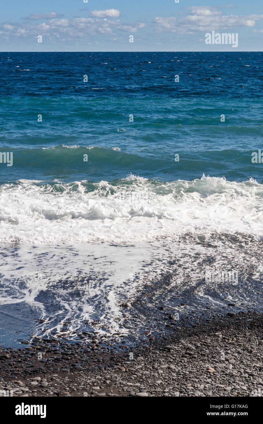 Costa sassosa e oceano onde con differenti tonalità di colore, composizione verticale Foto Stock