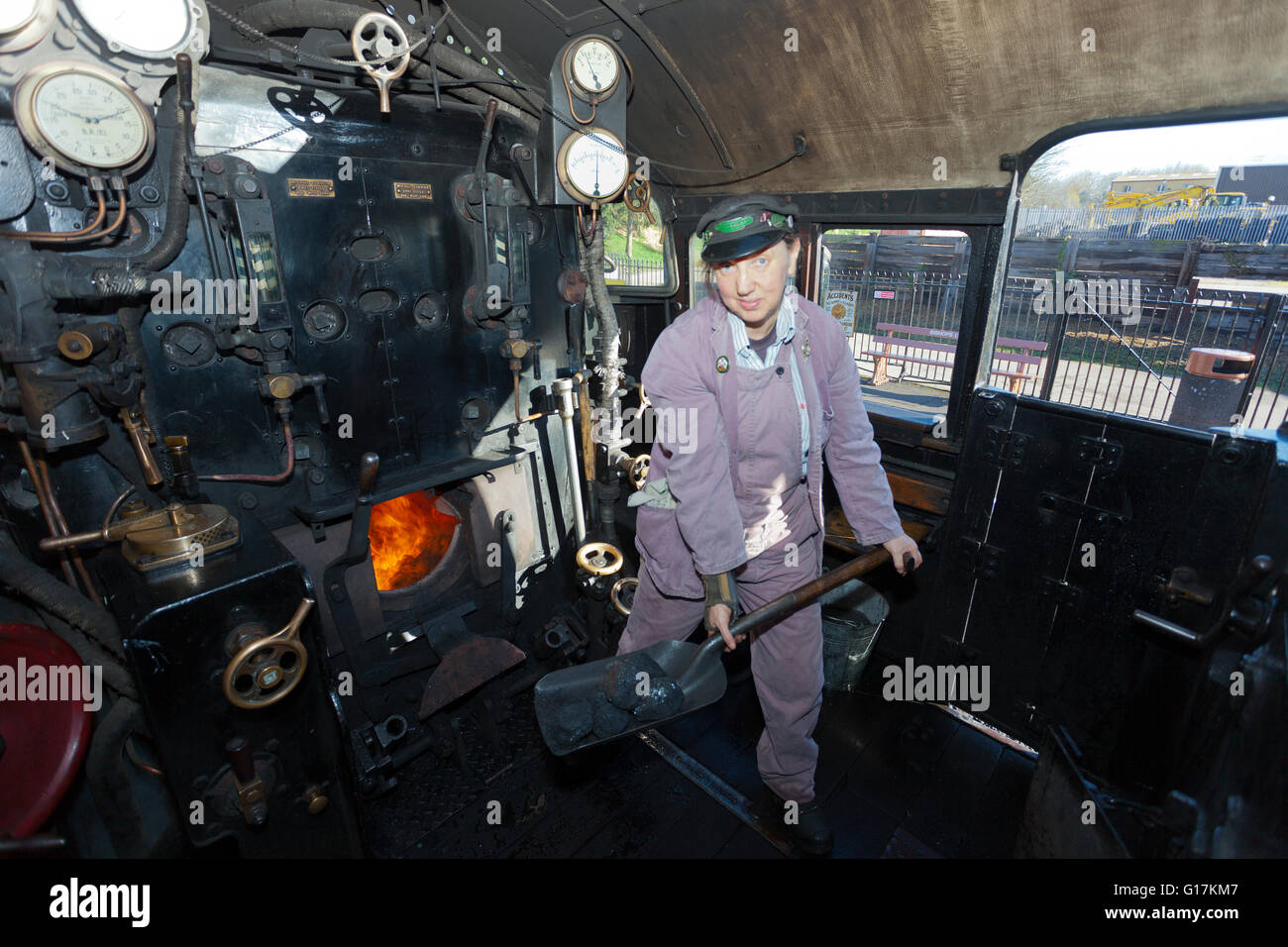 Una signora 'fireman' sul pavimento della Ex-BR serbatoio 80043 loco presso il West Somerset Railway, England, Regno Unito Foto Stock