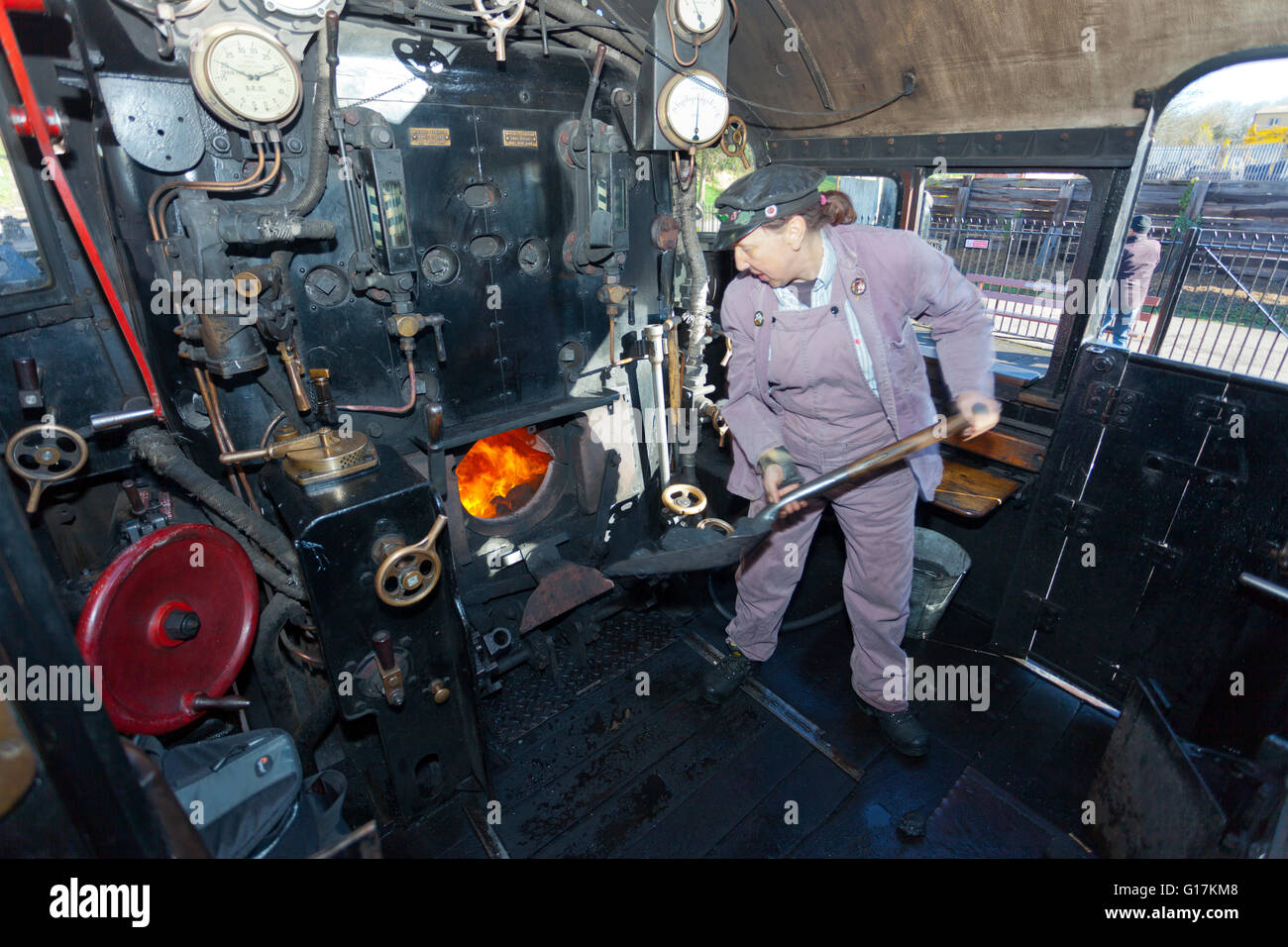 Una signora 'fireman' sul pavimento della Ex-BR serbatoio 80043 loco presso il West Somerset Railway, England, Regno Unito Foto Stock