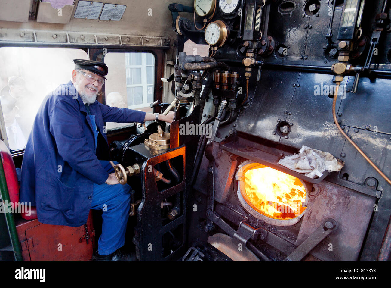 Autista Colin Henderson sulla pedana di un ex-BR 9F locomotiva merci 92214 sulla West Somerset Railway, England, Regno Unito Foto Stock