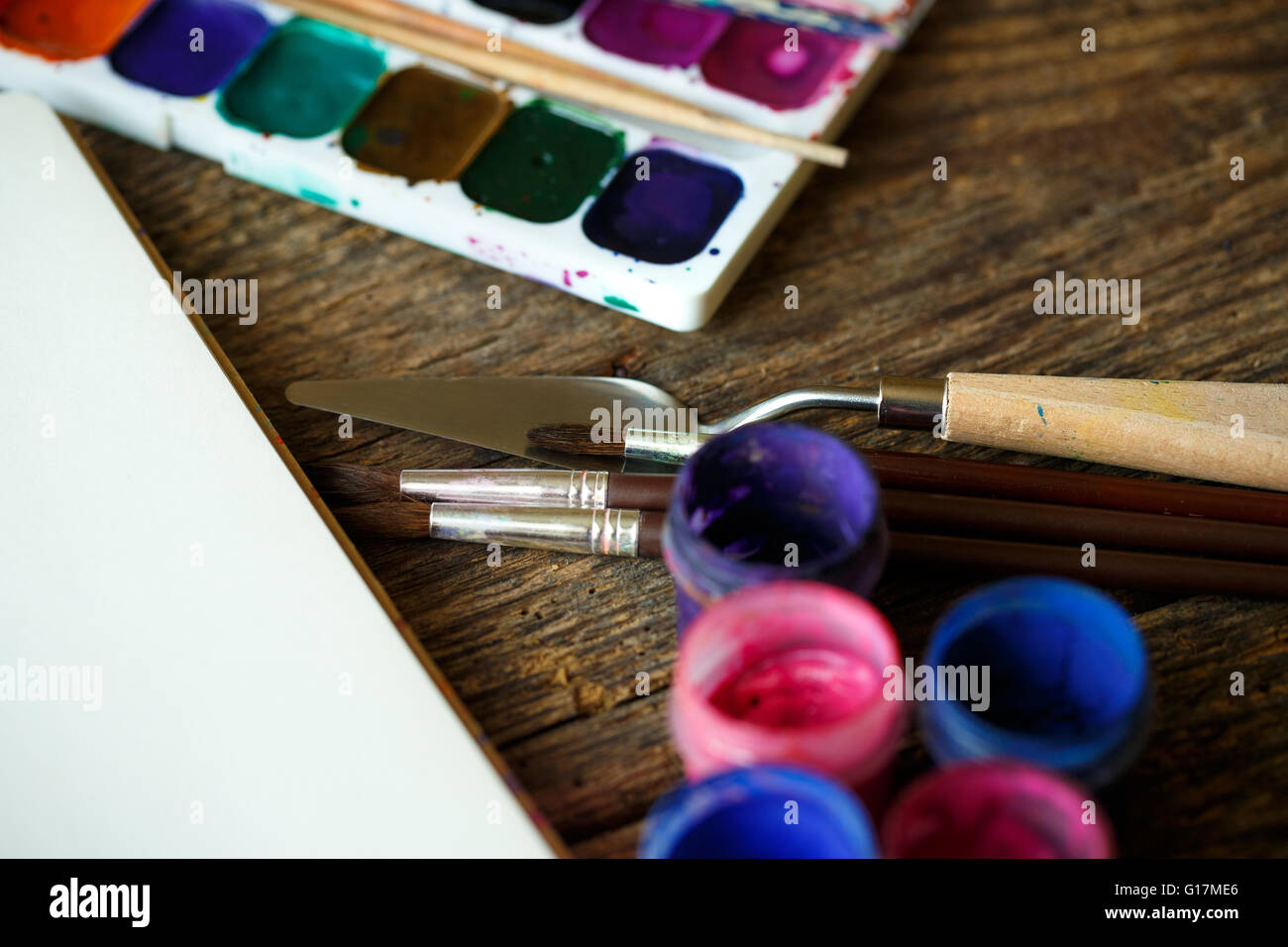 L'arte della pittura. Set di pittura: carta, spazzole, vernici, pastelli, acquerelli, vernice acrilico su uno sfondo di legno Foto Stock