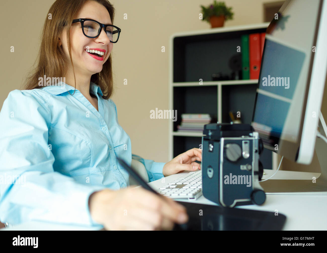 Giovane donna artista disegno qualcosa sulla tavoletta grafica presso l'ufficio a casa Foto Stock