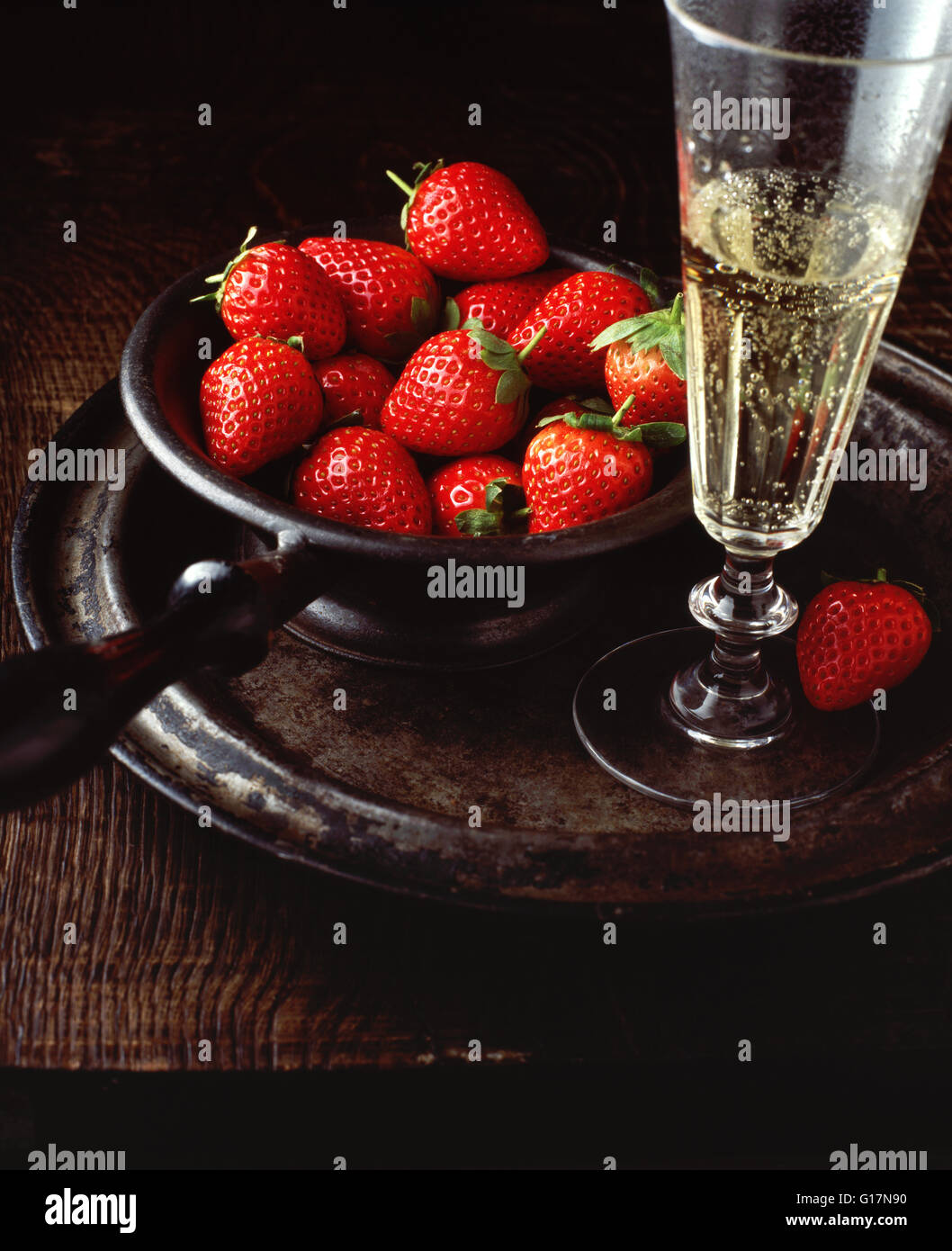 Vintage ciotola con le fragole e champagne, sulla piastra di peltro,  close-up Foto stock - Alamy