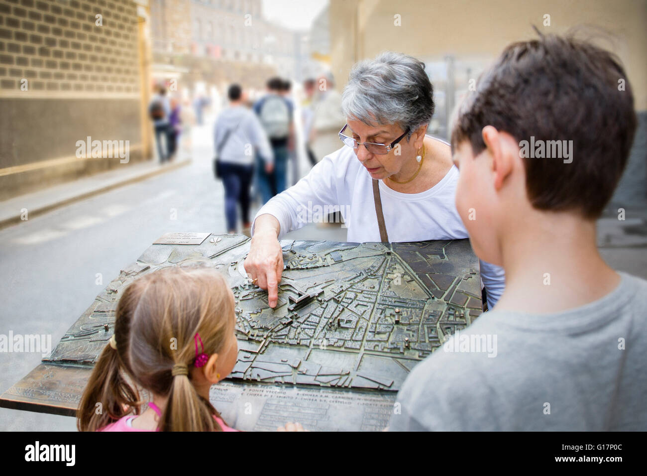 Donna senior e i nipoti puntando alla mappa della città, Firenze, Italia Foto Stock