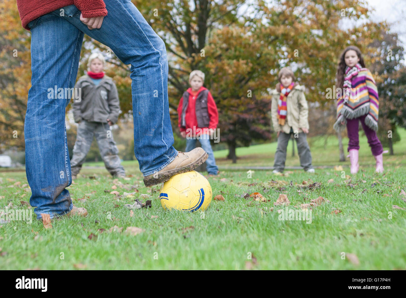 Padre e figli, giocando a calcio in posizione di parcheggio Foto Stock