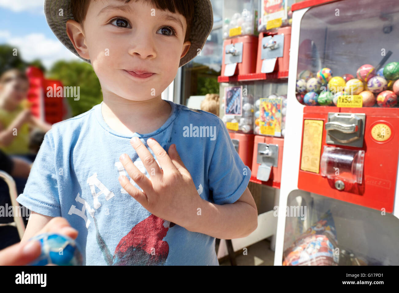 Felice ragazzo accanto a gumball machine Foto Stock