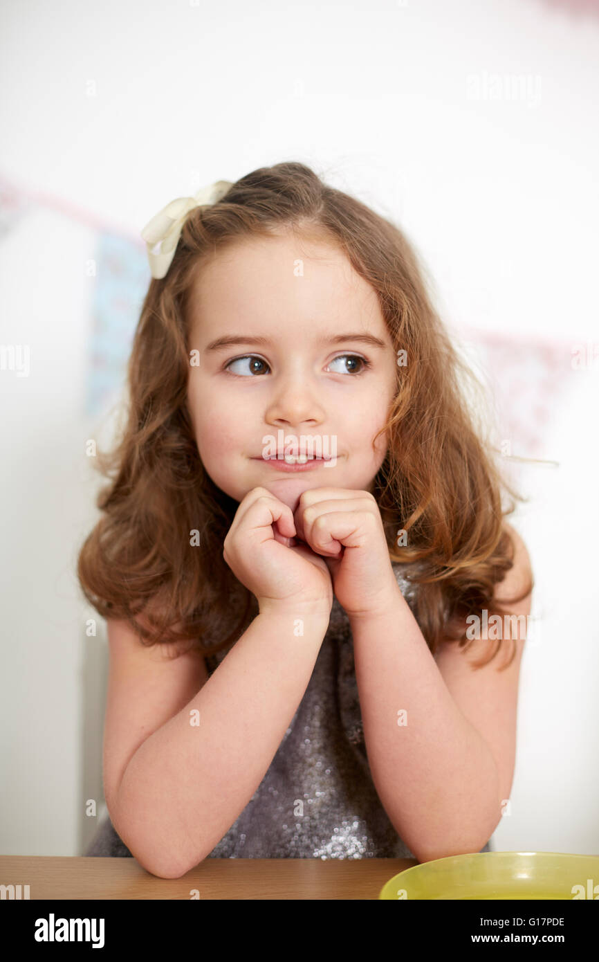 Ragazza con bunny denti fantasticando a tavola Foto Stock