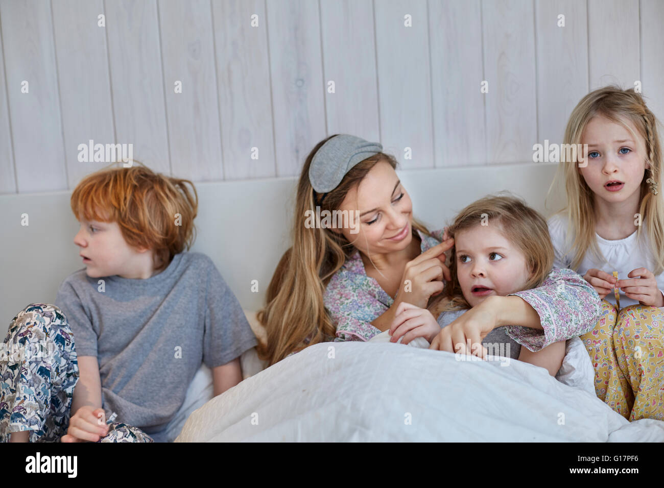 Madre e figli insieme a letto Foto Stock