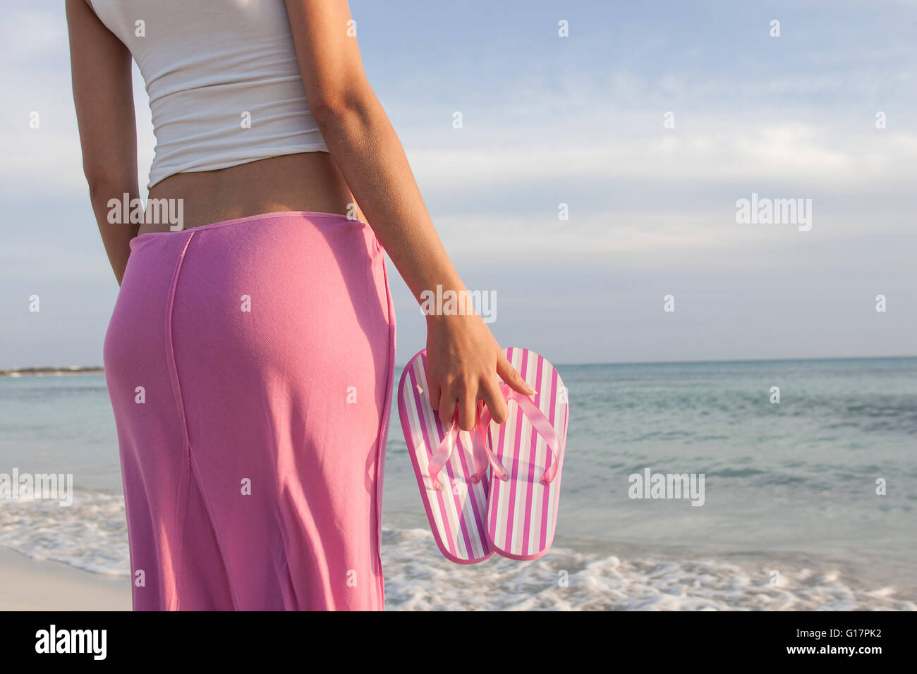 Ritagliato colpo di donna sulla spiaggia a strisce di contenimento rosa flip flop, Maiorca, SPAGNA Foto Stock