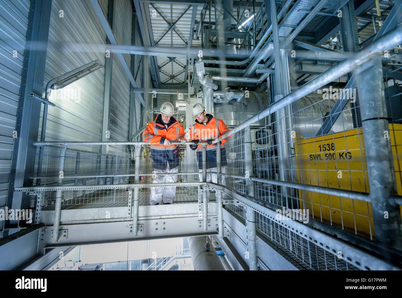 Lavoratori a livello alto la passerella in una centrale elettrica a gas Foto Stock