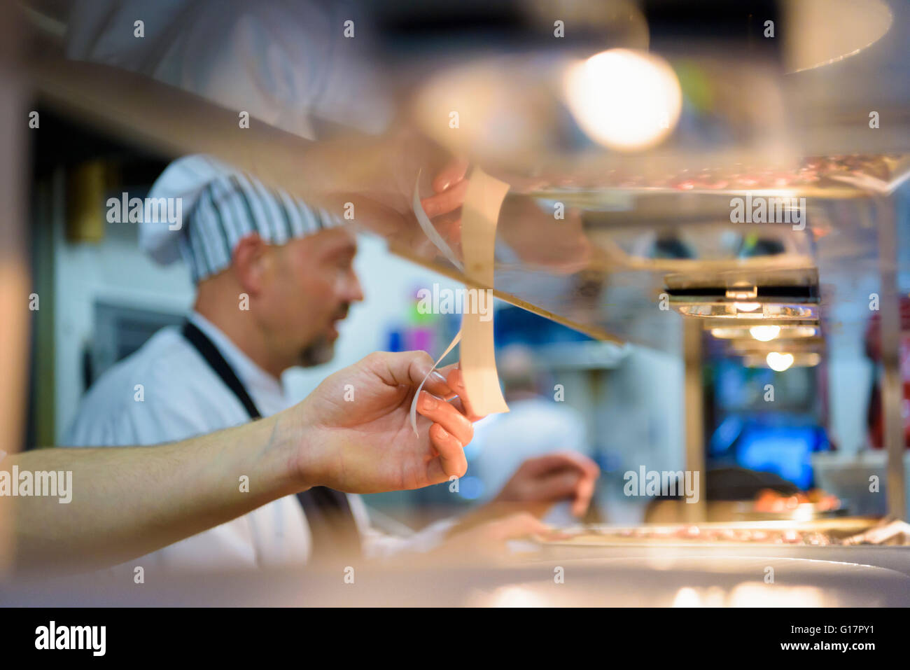 Lo Chef controllo ordine in un tradizionale ristorante italiano cucina Foto Stock