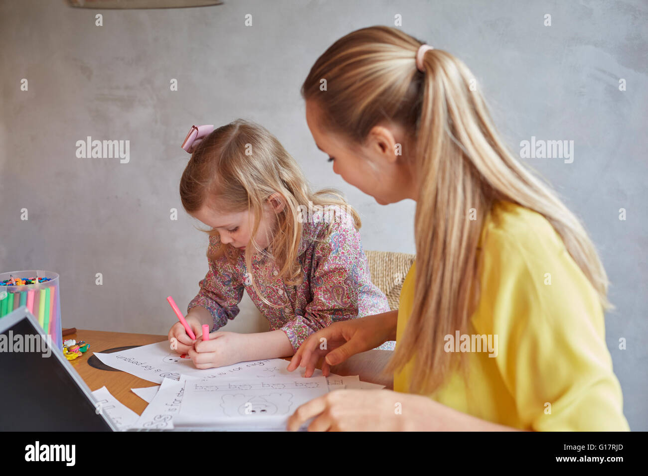 Madre figlia di insegnamento per scrivere a scrivania Foto Stock