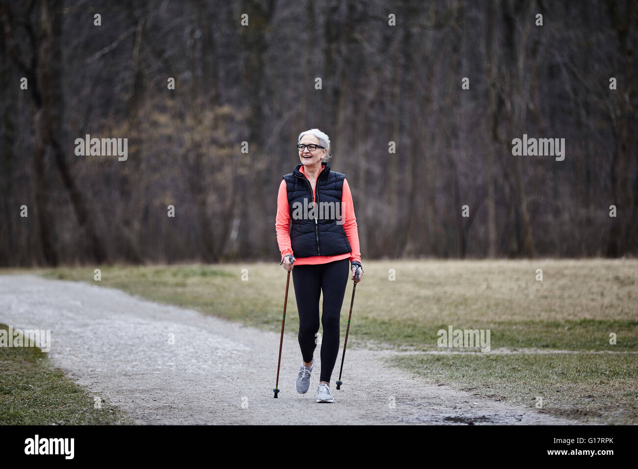 Femmina matura la formazione nel parco, nordic walking con poli Foto Stock